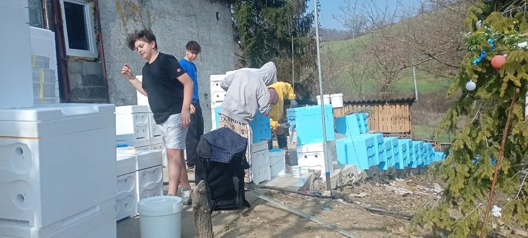 Persone al lavoro tra le attrezzature dell’apiario